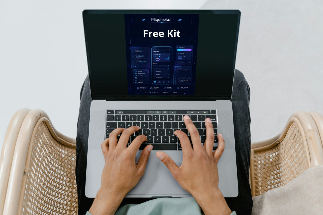 Person using a laptop with a screen displaying 'Free Kit' on a light background